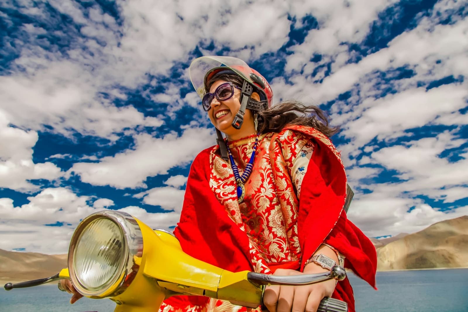 A woman travelling by scooter beside Pangong Lake, Ladakh